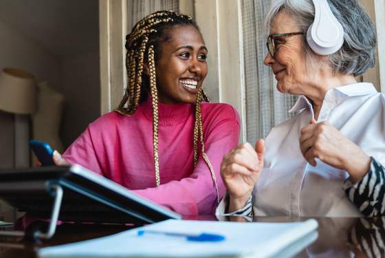 caregiver and elderly women listening to music. blog cover for firstlight home care brain injury awareness month